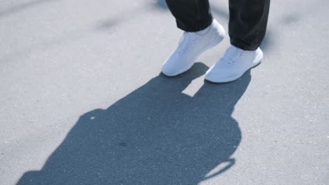 young man walking with guitar on street near forest