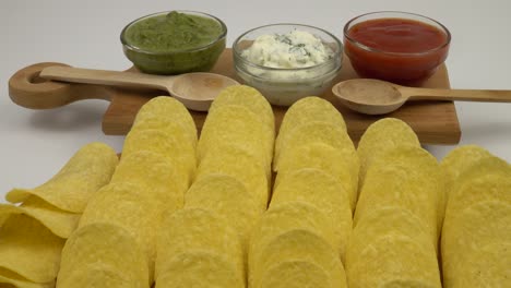 bowls with different sauce and potato chips