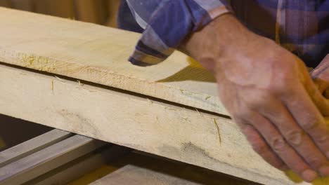 un maestro carpintero acariciando madera cruda con sus manos. un empleado que ama su trabajo.