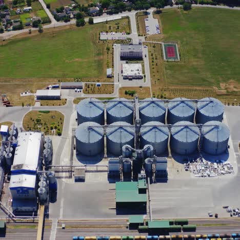 grain elevators on field. silver silos on plant for processing agricultural products. view from above on a modern granary for storing harvest. aerial view.