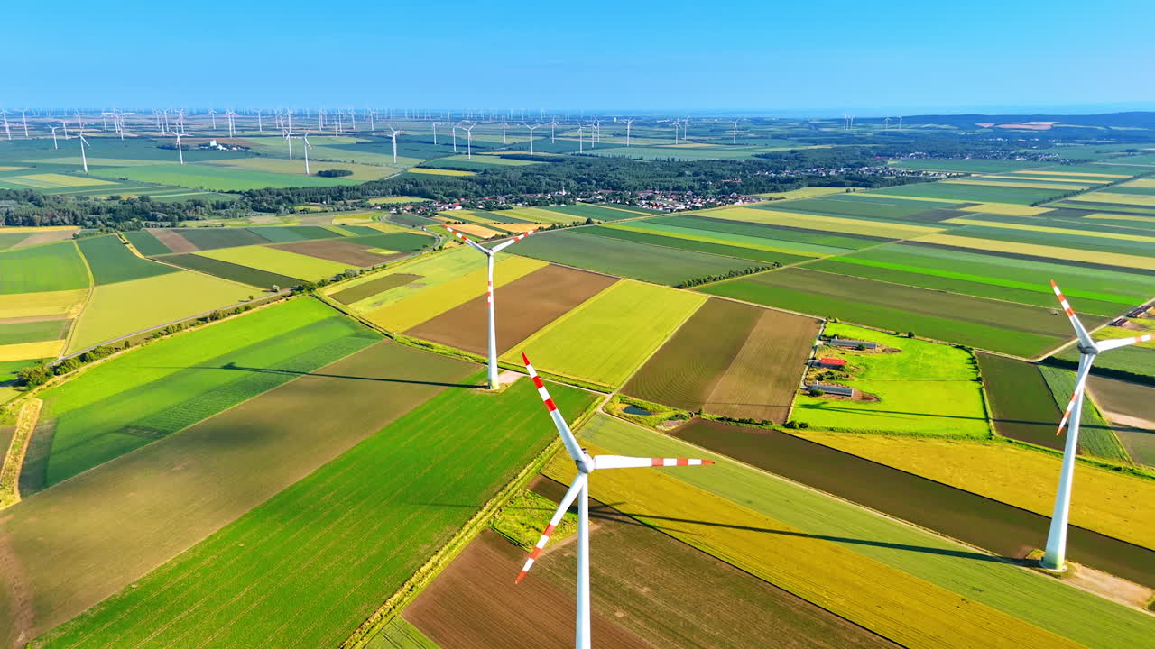Turbines capturing rural energy. Wind turbines turn in lush fields under a blue sky, highlighting renewable energy in rural areas