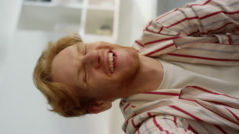 guy laughing webcam call at home interior closeup. joyful ginger man talk online