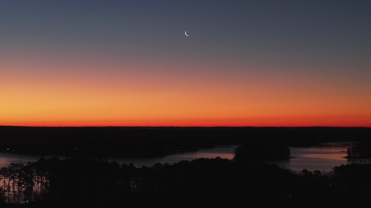 Morgendlicher Himmel über dem Lake Lanier mit dem Mond im Hintergrund, Drohnenansicht