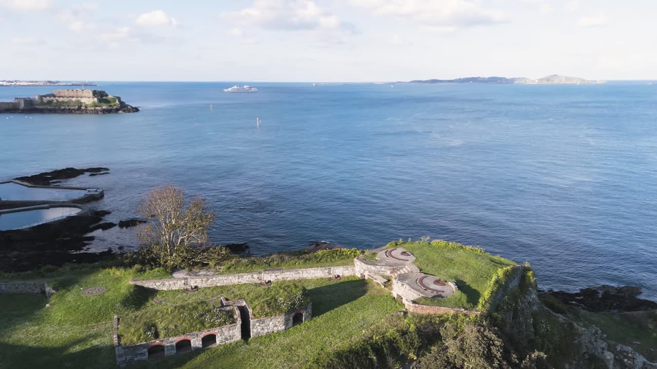 panning drone imágenes de la batería de clarence st peter puerto de guernsey con vistas al castillo cornet sobre el mar piscinas de baño en un día soleado