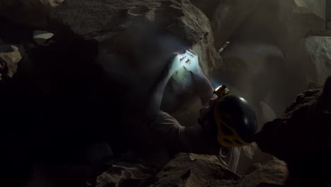caver illuminates a dark cave