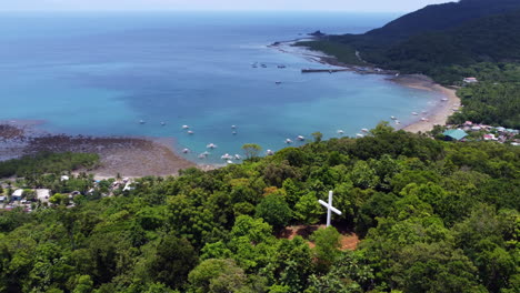 Disparo-En-órbita-Desde-La-Bendición-De-La-Cruz-Blanca-Vista-Espectacular-Del-Paisaje-Marino-Bajo-Un-Cielo-Azul,-Colina-Ermita,-Empacadora