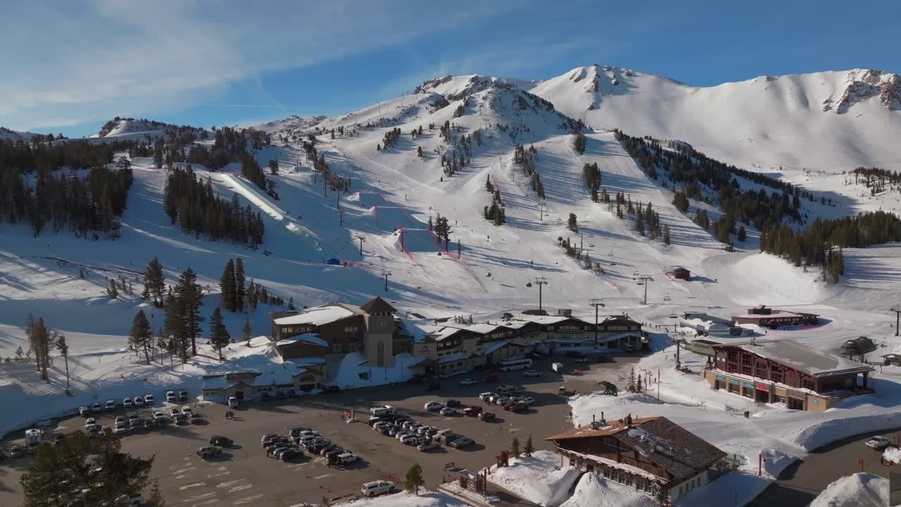 Mammoth Mountain ski resort spring Main Lodge California aerial drone Unbound Terrain Parks panorama landscape ski snowboard trail runs chairlift gondola cars parking lot sunny blue sky forwards