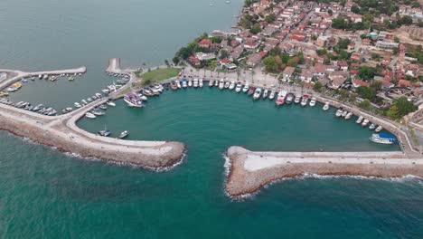 Aerial-view-circling-above-Side-old-city-crescent-shaped-marina-on-the-Alanya-resort-coastline-of-Turkey