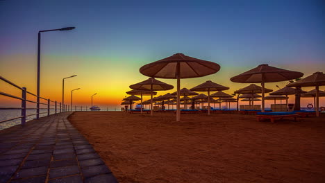 Beach-umbrellas-along-a-beach-in-the-Red-Sea-at-sunrise---time-lapse
