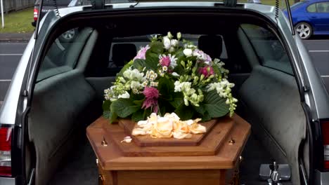 closeup shot of a funeral casket or coffin in a hearse or chapel or burial at cemetery