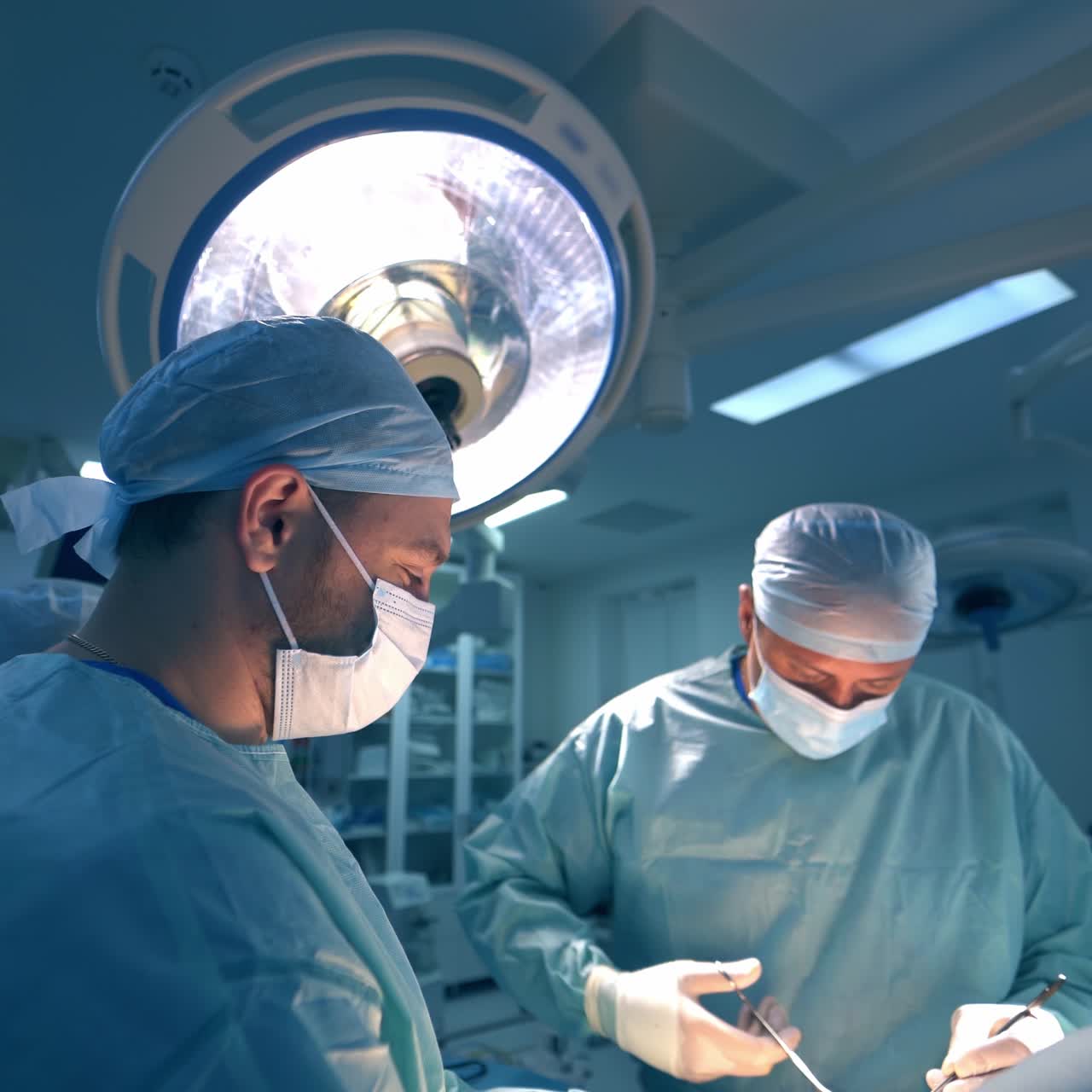 Professional surgeon team conducting operation in surgical theatre. Male team doing plastic surgery in modern hospital