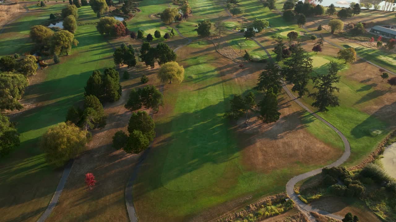 이른 아침 햇살 아래 빛나는 골프 코스의 오버헤드 조감도