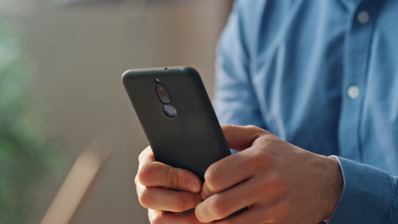 los dedos del hombre de negocios sosteniendo el gabinete del teléfono inteligente en primer plano. hombre enviando mensajes de texto al teléfono móvil