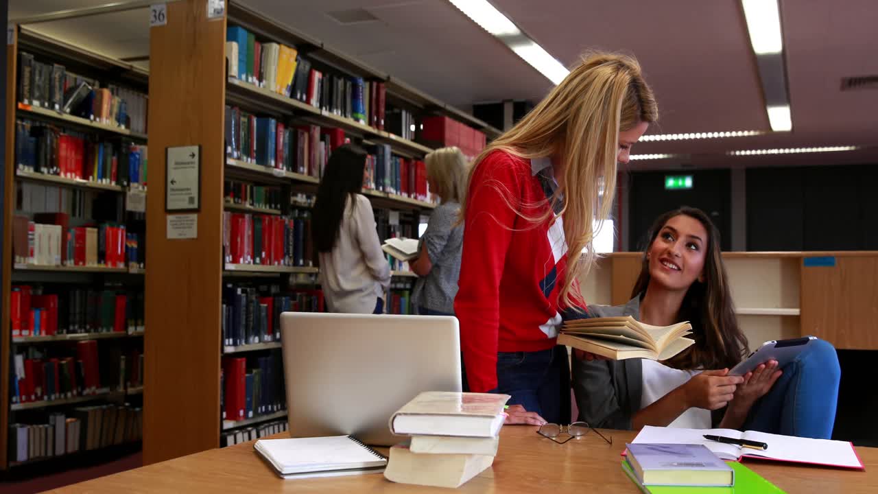 Studenti sorridenti che imparano con un laptop.