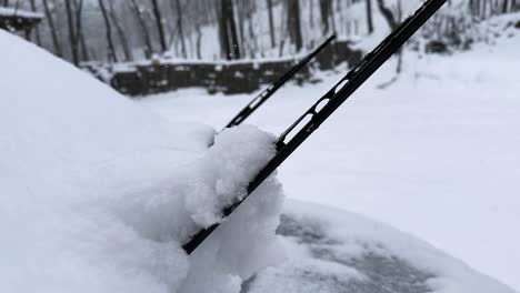 snow wiper of a car in heavy snow in rural village countryside iran winter season icy windshield in nature of hyrcanian forest scenic landscape cabin woods in travel freezing mountain frost cabin