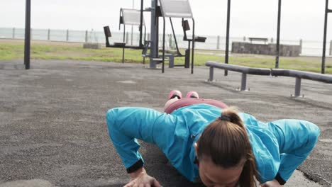 sporty caucasian woman exercising in an outdoor gym during daytime