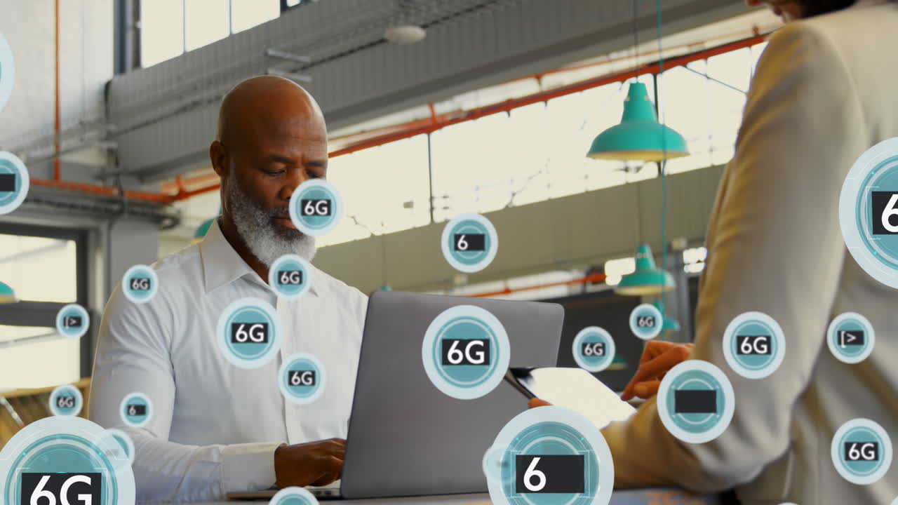 Animation of 6g texts and symbols over diverse coworkers using laptop and digital tablet
