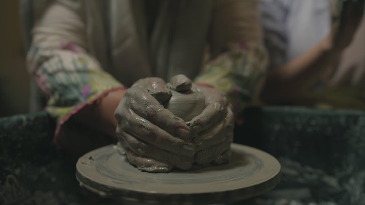 sculpting spinning clay with firm hands in pottery process