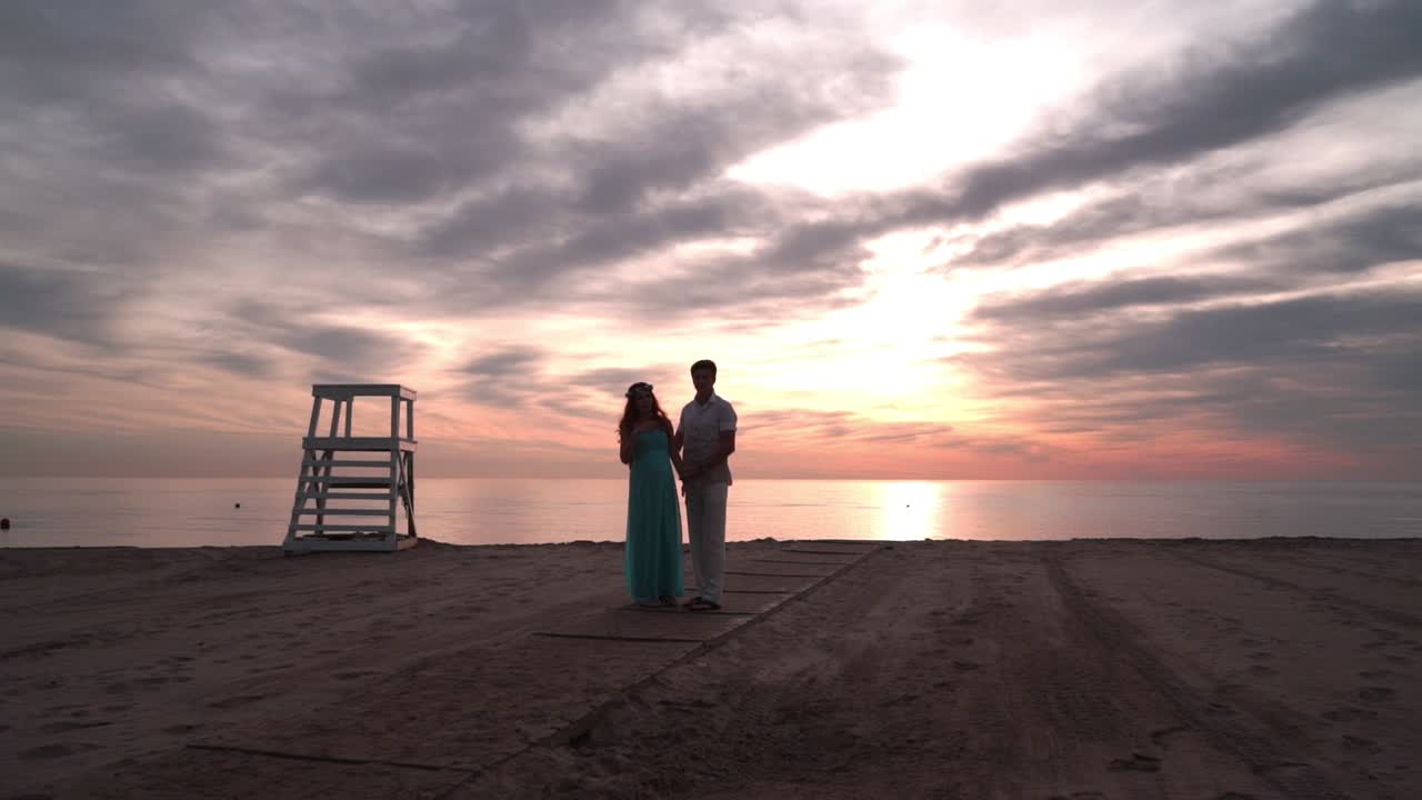 pareja embarazada hablando al atardecer. concepto de amor. pareja romántica en la playa