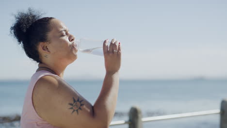 plus size woman drinking water from bottle