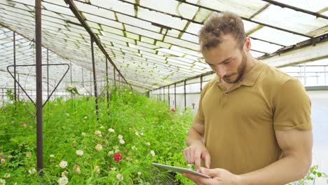 joven jardinero moderno trabajando con una tableta.