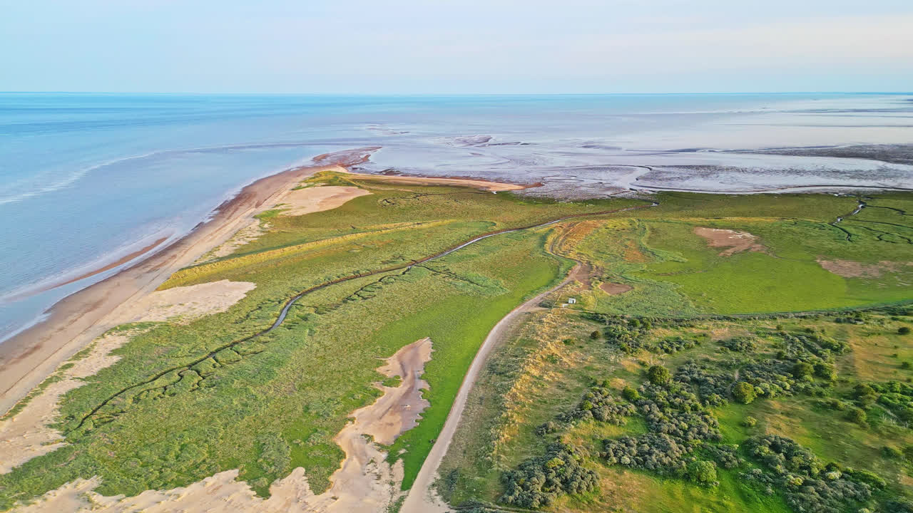 откройте для себя идиллическое очарование прибрежной сцены золотого часа с помощью захватывающих воздушных снимков: устье реки, песчаные берега, океан и болота