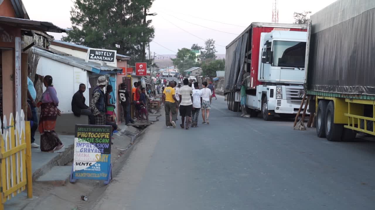 Busy Madagascan street scene. Wide shot along road