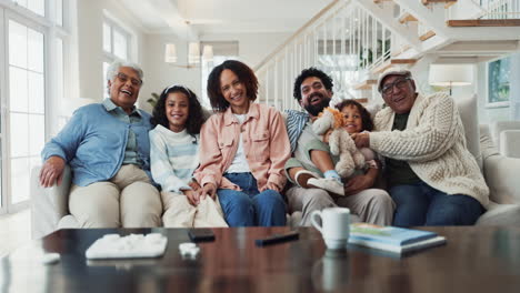 a happy multi-generational family posing together on a couch