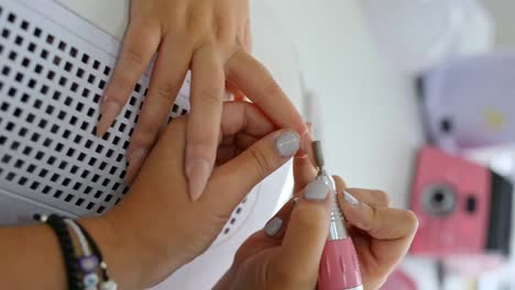 crop nail artist removing nail polish of customer in salon