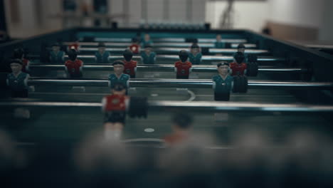 closeup miniature plastic figures on football table. children hands revolve rods