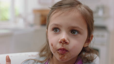 una niña linda con las manos cubiertas de chocolate lamiendo los dedos divirtiéndose horneando en la cocina un niño travieso disfrutando de una deliciosa golosina en casa