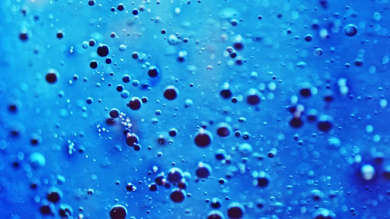 foto macro de pequeñas burbujas de tinta azul flotando en el agua