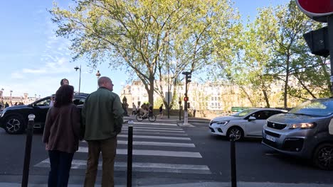 pedestrians waiting to cross a busy street