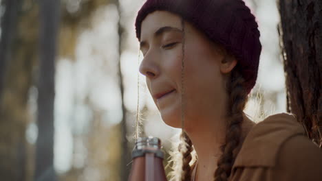 female tourist with eyes closed in forest