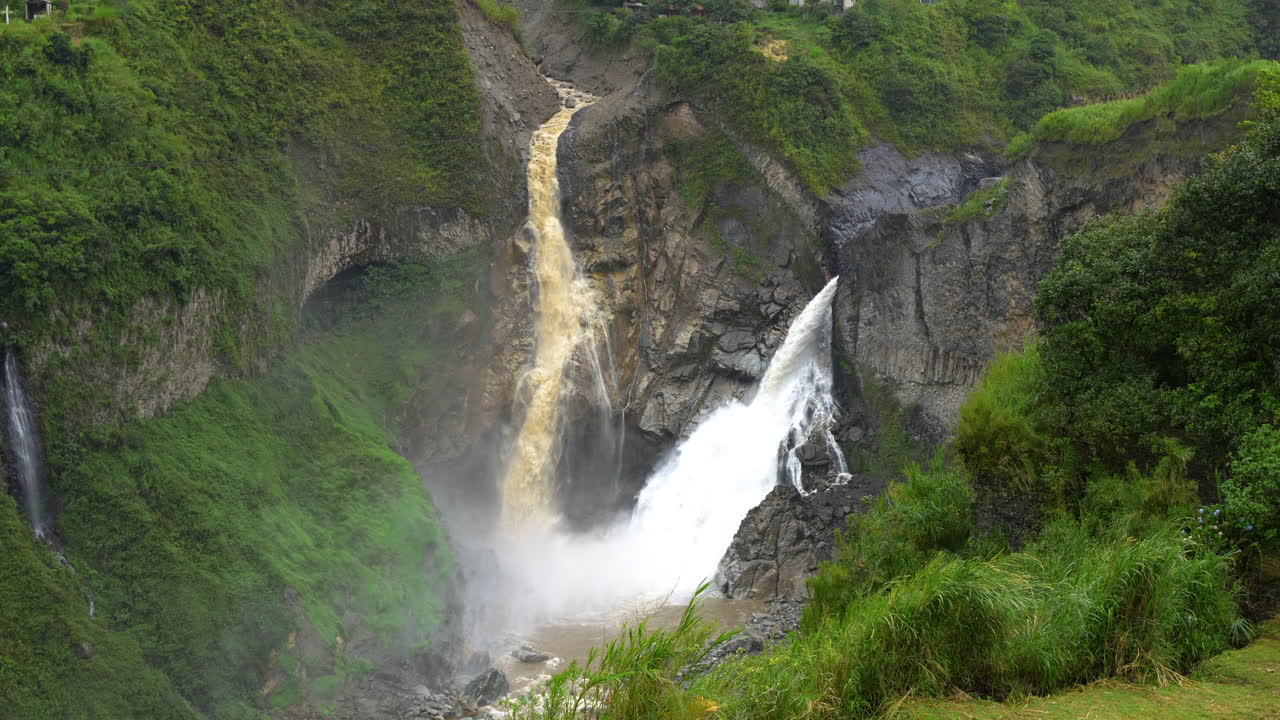 enorme cascada estrellándose contra la selva amazónica verde en ecuador, vista aérea en cámara lenta de arriba hacia abajo
