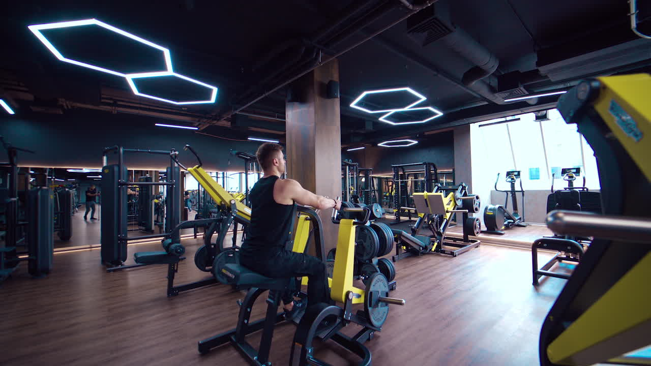 Hombre entrenando en el gimnasio. Hombre culturista fuerte haciendo curl de bíceps en un club deportivo.