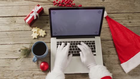 santa claus using laptop with copy space over christmas decorations