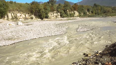 agua turbia que fluye hacia el lecho del río erosionándolo