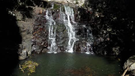 El-Agua-Cae-Lentamente-Por-Una-Cascada-Aislada-De-La-Selva-Tropical-Hacia-Una-Piscina-Natural