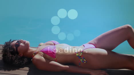 loading animation over woman sunbathing in pink bikini by pool