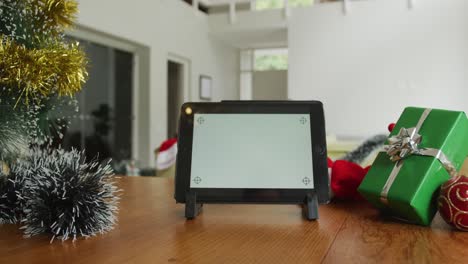 Nahaufnahme-Eines-Tablets-Mit-Kopierplatz-Auf-Dem-Bildschirm,-Zu-Weihnachten-Auf-Dem-Tisch-Im-Wohnzimmer-Sitzend