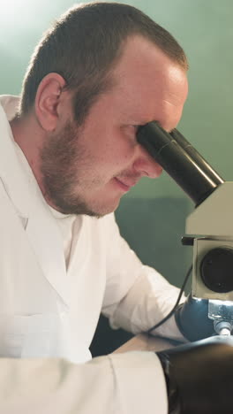 una vista de cerca de un técnico dedicado en una bata de laboratorio, trabajando intensamente en una placa de circuitos electrónicos bajo un microscopio