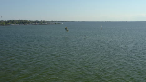 a windsurfer with a parachute floats on a board