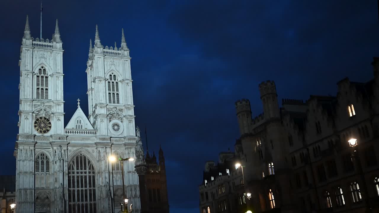 vista nocturna del tráfico que pasa por la abadía de westminster, londres, reino unido
