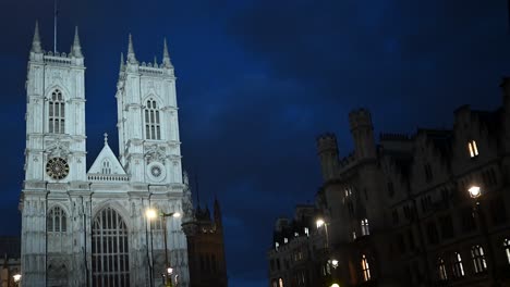 vista nocturna del tráfico que pasa por la abadía de westminster, londres, reino unido