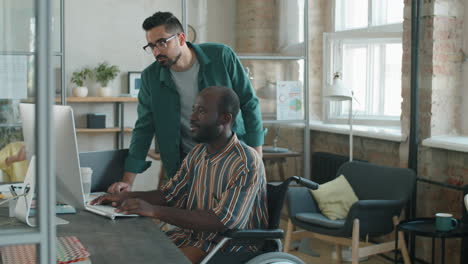 middle eastern businessman working with african american colleague in wheelchair