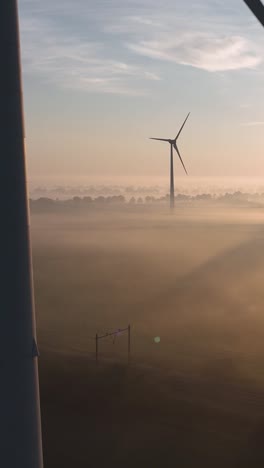 misty sunrise over wind farm