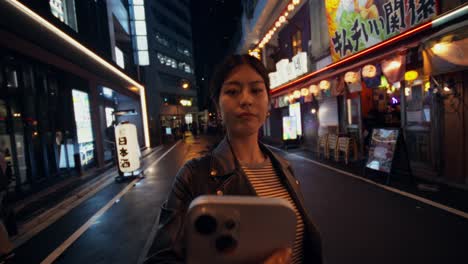 happy woman taking a selfie in a japanese city at night