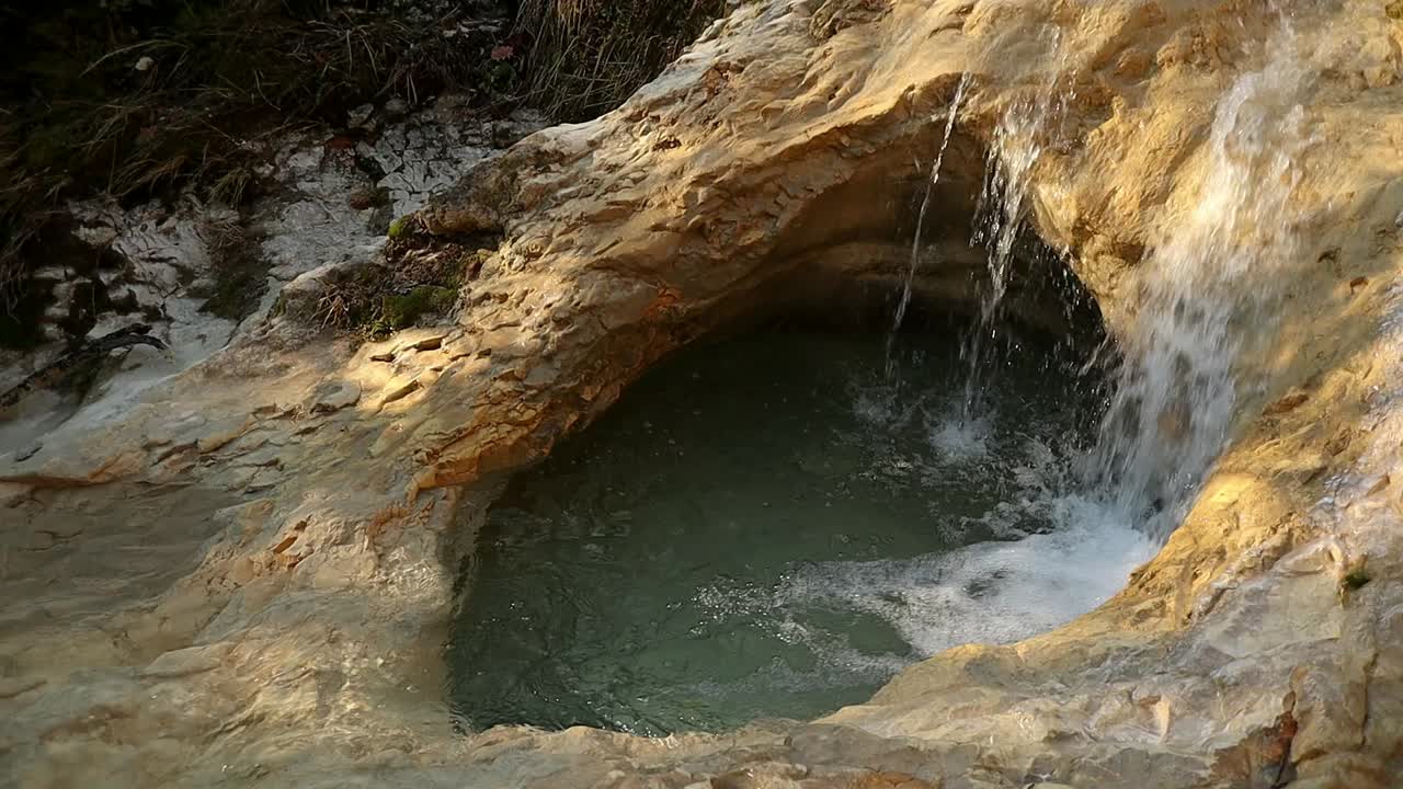 물이 흐르는 바위의 자연 구멍, 일몰 시 근접 촬영