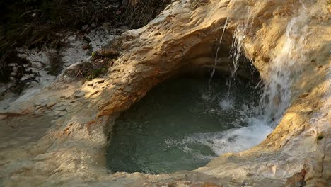 natural hole in the rock where water flows, close up shot at sunset